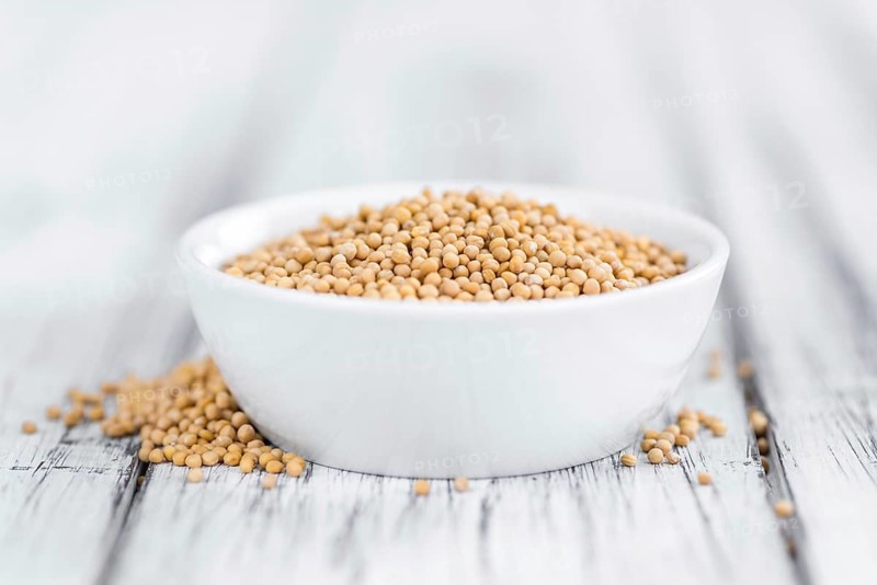 Seeds (Mustard) as high detailed close-up shot on a vintage wooden table (selective focus)
