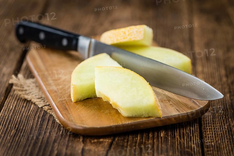 Honeydew Melon on an old wooden table as detailed close-up shot (selective focus)