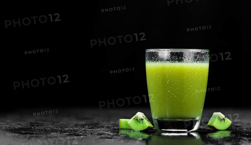 Some fresh homemade Kiwi Smoothies on a slate slab (close-up shot, selective focus)
