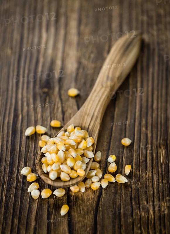 Portion of Corn (detailed close-up shot) on wooden background (selective focus)