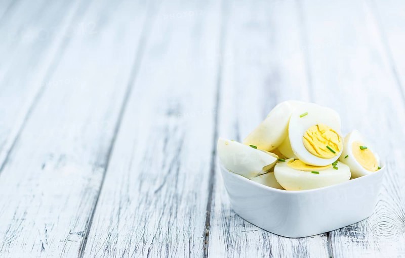 Wooden table with halved Eggs (selective focus, close-up shot)
