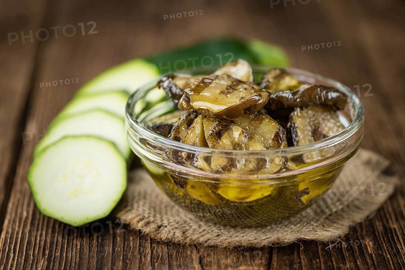 Zucchinis (grilled) as high detailed close-up shot on a vintage wooden table (selective focus)