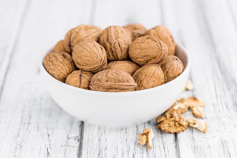 Walnuts on an old wooden table as detailed close-up shot (selective focus)