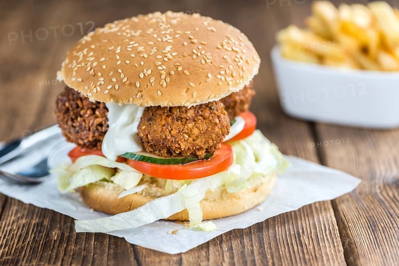 Wooden table with a homemade Falafel Burger (selective focus)