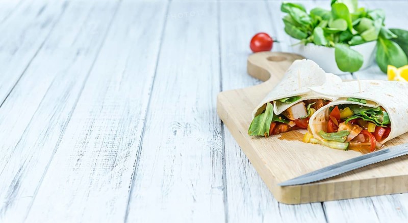 Chicken Wraps on a wooden table as detailed close-up shot (selective focus)