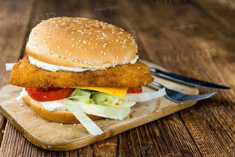 Fish Burger on wooden background (close-up shot, selective focus)