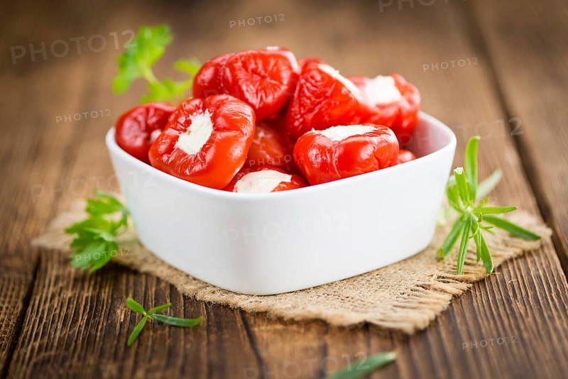 Fresh made Red Pepper (stuffed with cheese) on an old and rustic wooden table (selective focus, close-up shot)