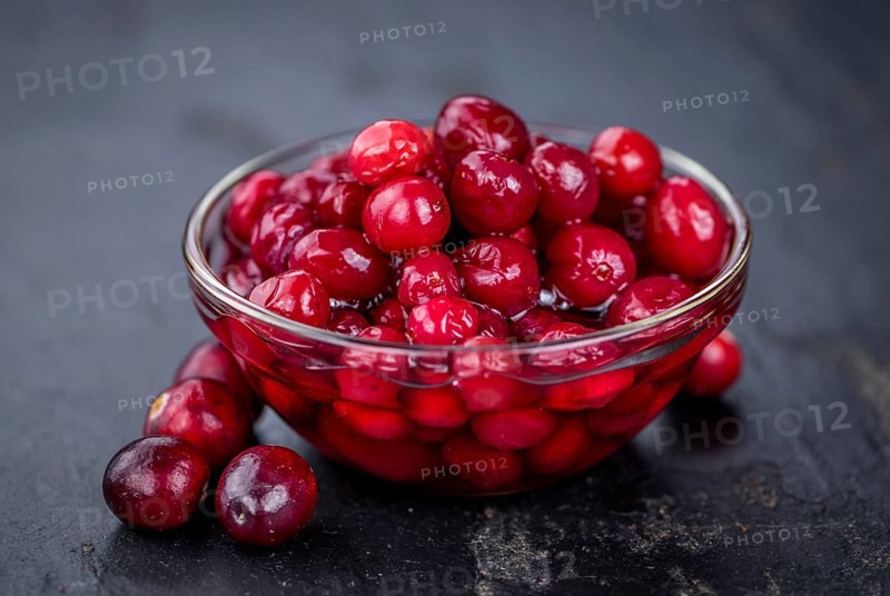 Some healthy Preserved Cranberries on a vintage slate slab (selective focus)