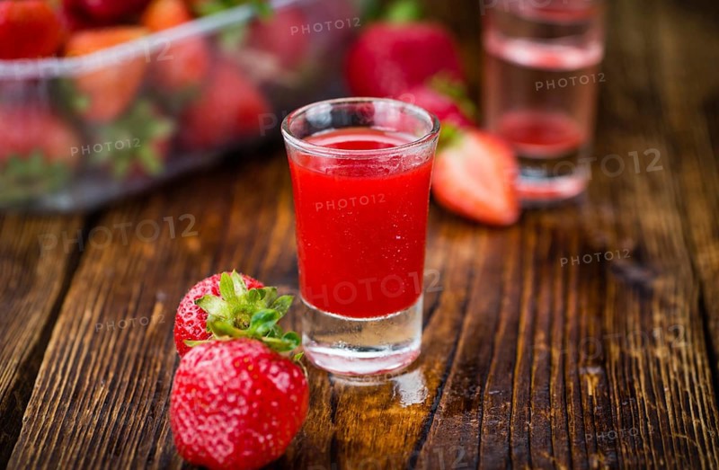 Fresh made Strawberry liqueur on an old and rustic wooden table, selective focus, close-up shot
