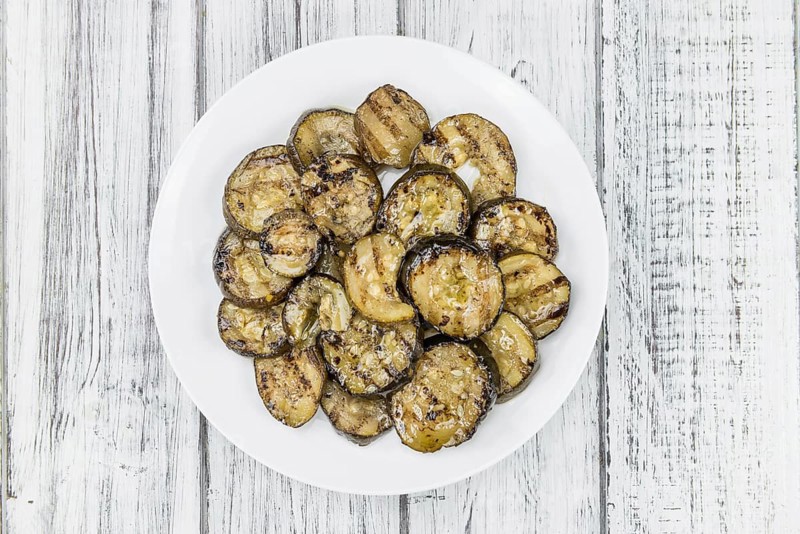 Zucchinis (grilled) as high detailed close-up shot on a vintage wooden table (selective focus)