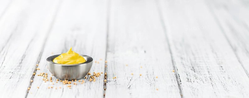 Fresh made Mustard on a vintage background (close-up shot)