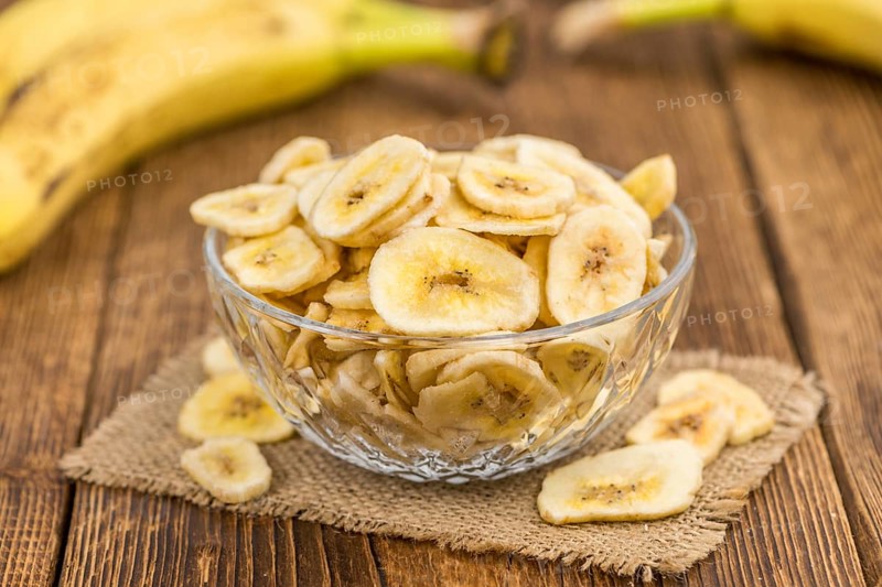 Fresh made Dried Banana Chips on an old and rustic wooden table, selective focus, close-up shot