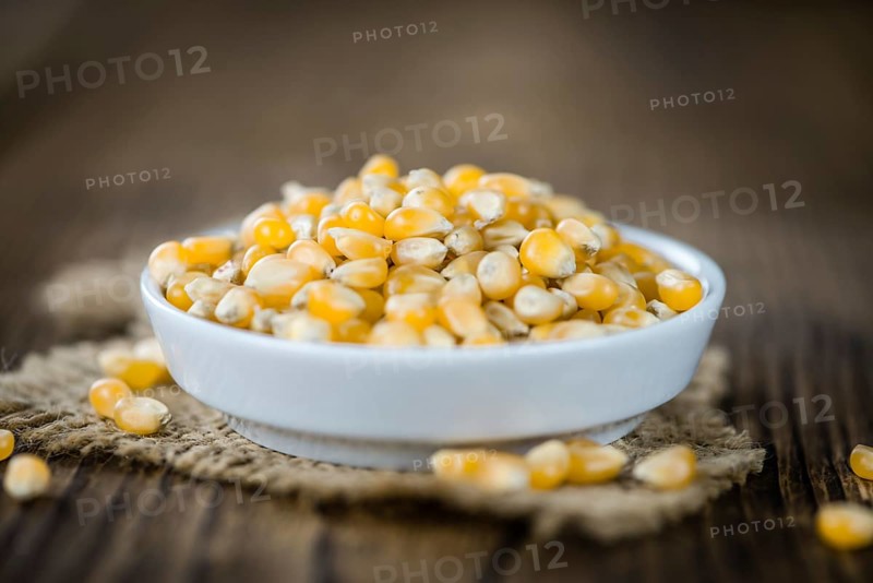 Portion of Corn (detailed close-up shot) on wooden background (selective focus)