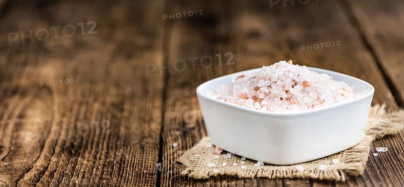 Himalayan Salt as high detailed close-up shot on a vintage wooden table (selective focus)