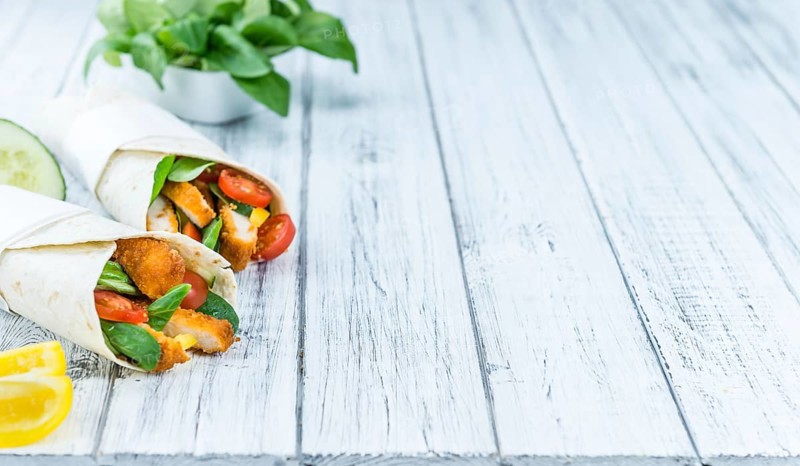 Portion of Chicken Wraps (selective focus) on an old wooden table