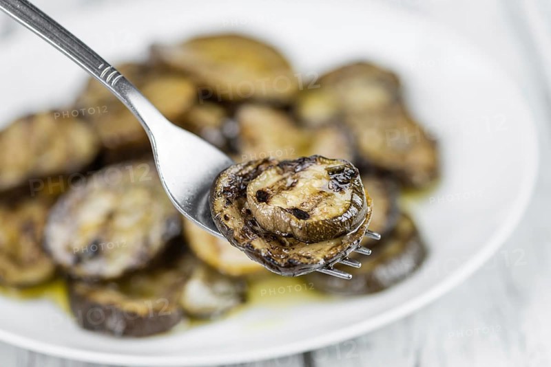 Fresh made Zucchinis (grilled) on an old and rustic wooden table (selective focus, close-up shot)