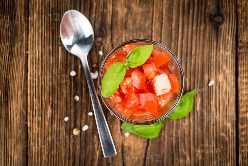 Homemade Diced Tomatoes on an wooden table (selective focus) as detailed close-up shot