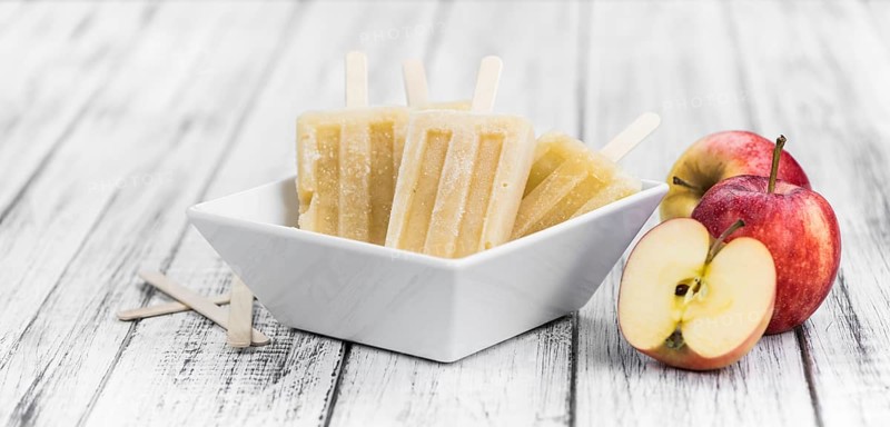 Apple Popsicles on an old wooden table (close-up shot, selective focus)