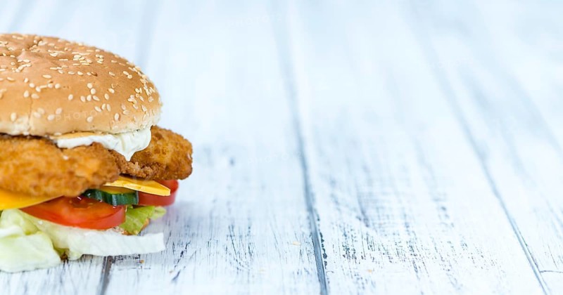 Homemade Fish Burger (close-up shot, selective focus) on a wooden table