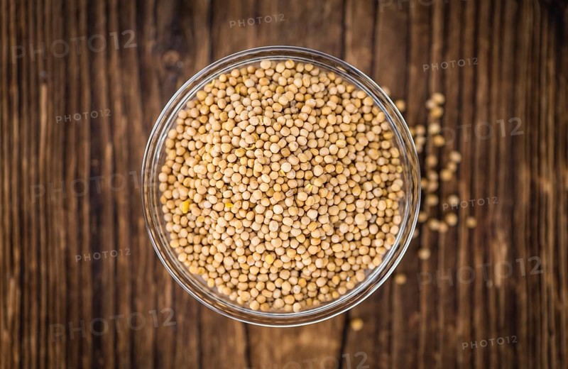 Seeds (Mustard) as high detailed close-up shot on a vintage wooden table (selective focus)