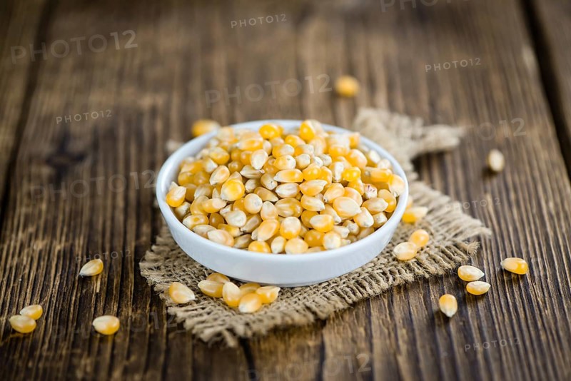Dried Corn (detailed close-up shot, selective focus) on vintage wooden background