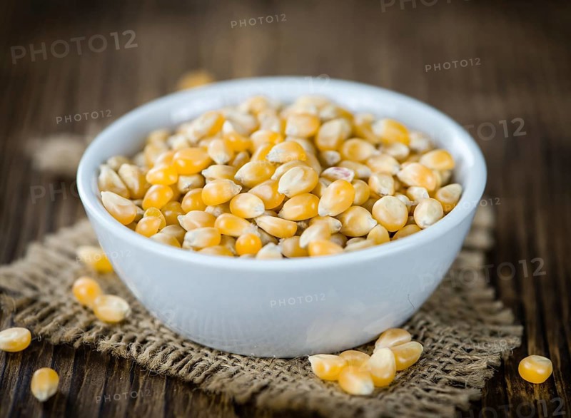 Portion of Corn (detailed close-up shot) on wooden background (selective focus)