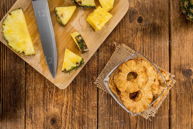 Pineapple rings (dried) on rustic wooden background as close-up shot