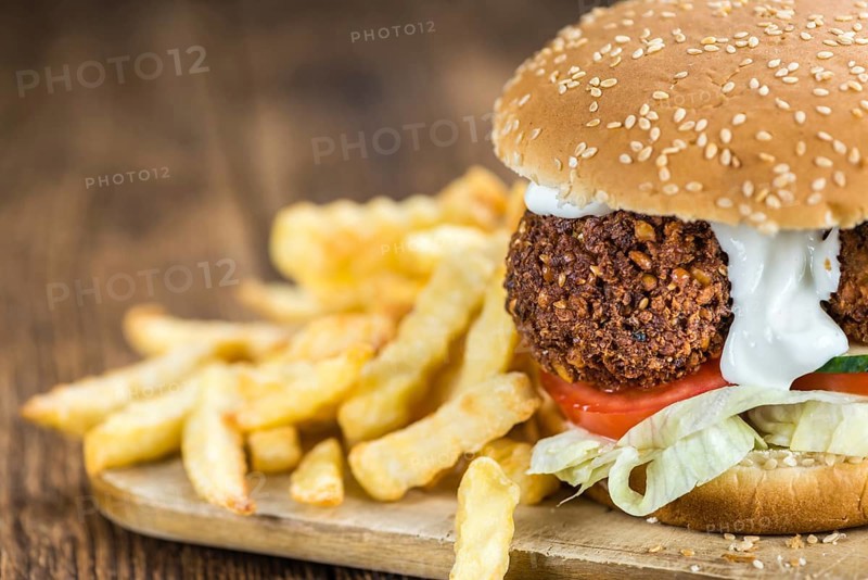 Fresh made Falafel Burger (close-up shot, selective focus) on wooden background
