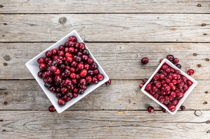 Vintage wooden table with Cranberries (preserved) (selective focus, close-up shot)