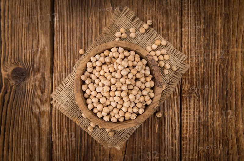 Dried Chickpeas as high detailed close-up shot on a vintage wooden table, selective focus