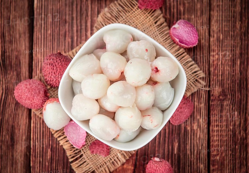 Litchis on rustic wooden background (close-up shot)