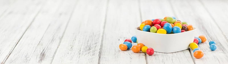 Cocolate coated Peanuts on an old wooden table as detailed close-up shot (selective focus)