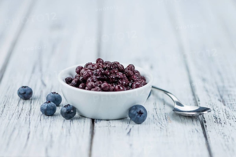 Homemade Preserved Blueberries on an wooden table as detailed close-up shot, selective focus