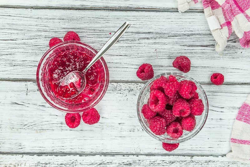 Fresh made Raspberry Jam on an old and rustic wooden table, selective focus, close-up shot