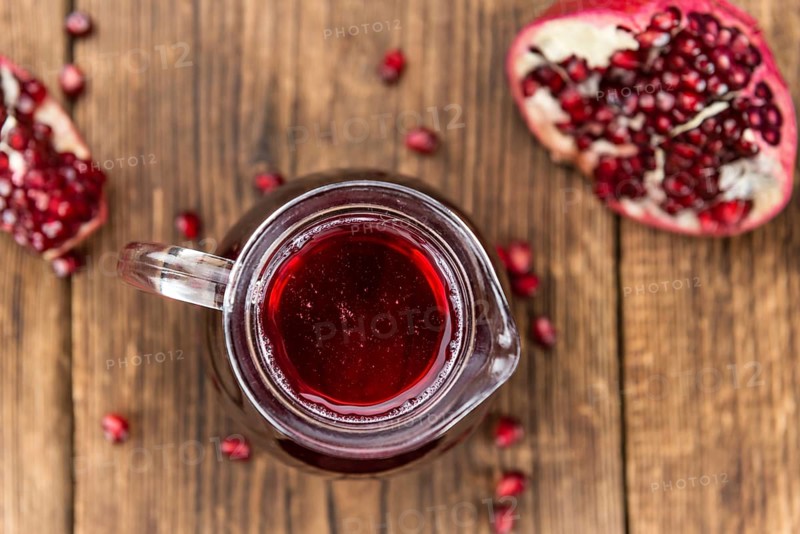 Fresh made Pomegranate juice on a vintage background (close-up shot)