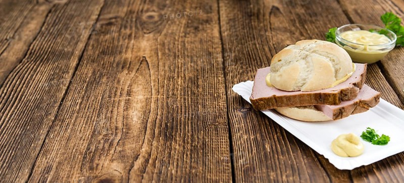 German Leberkaese as high detailed close-up shot on a vintage wooden table (selective focus)