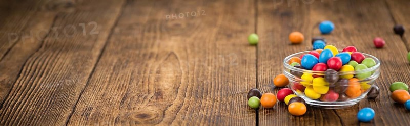 Cocolate coated Peanuts on an old wooden table as detailed close-up shot (selective focus)