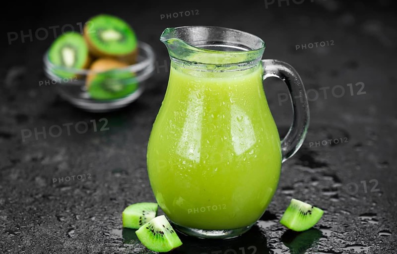Some fresh homemade Kiwi Smoothies on a slate slab (close-up shot, selective focus)