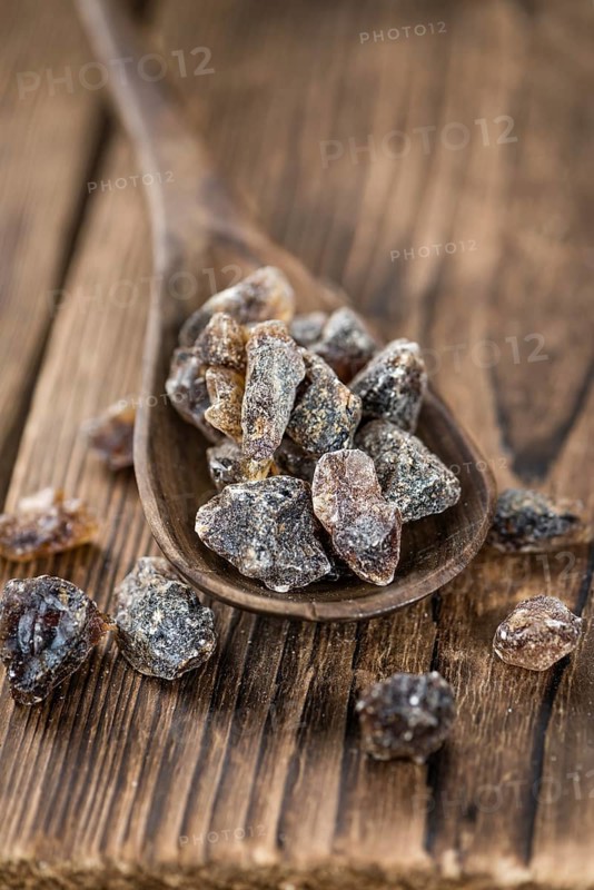 Wooden table with brown Rock Candy (close-up shot, selective focus)