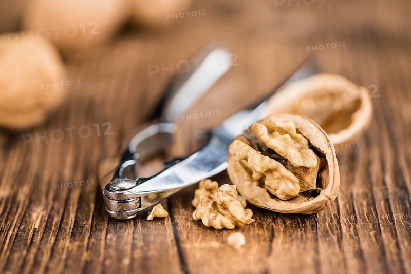 Walnuts on rustic wooden background (close-up shot)