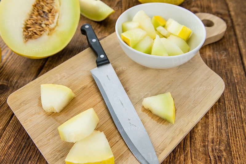 Honeydew Melon on an old wooden table as detailed close-up shot (selective focus)