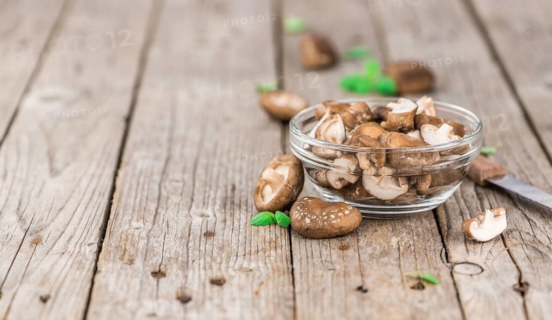 Shiitake mushrooms on an old wooden table as detailed close-up shot, selective focus