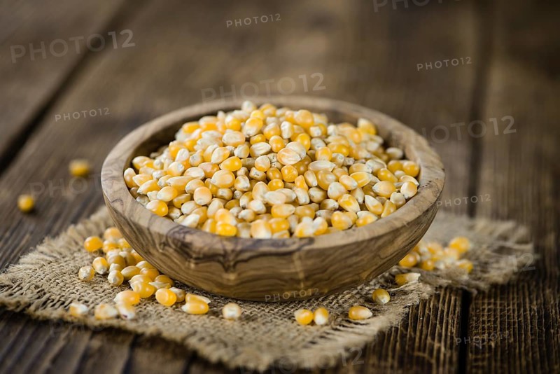 Portion of Corn (detailed close-up shot) on wooden background (selective focus)