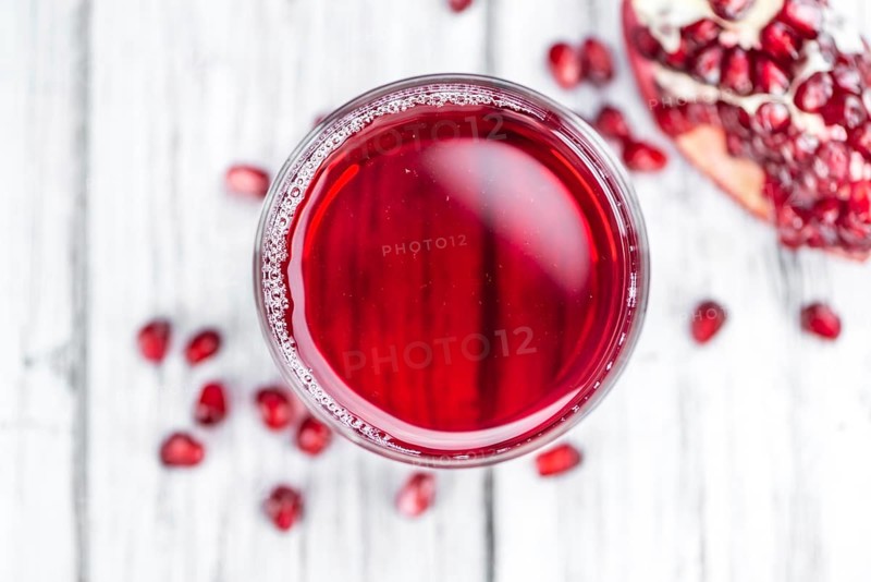 Pomegranate juice on a vintage background as detailed close-up shot (selective focus)