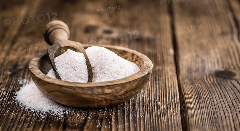 Pink Himalayan Salt on rustic wooden background (close-up shot)