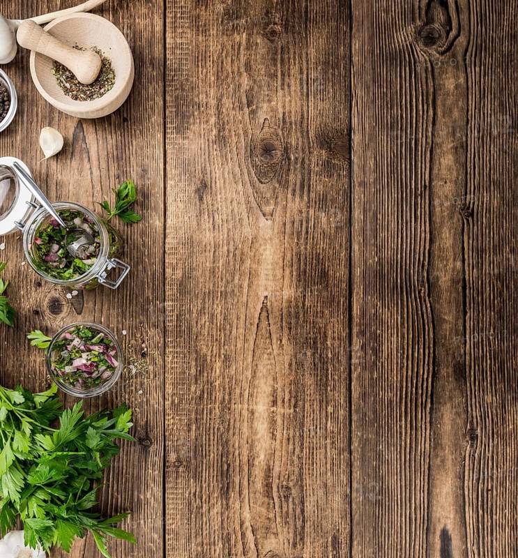 Healthy homemade Chimichurri on a wooden table as detailed close-up shot (selective focus)