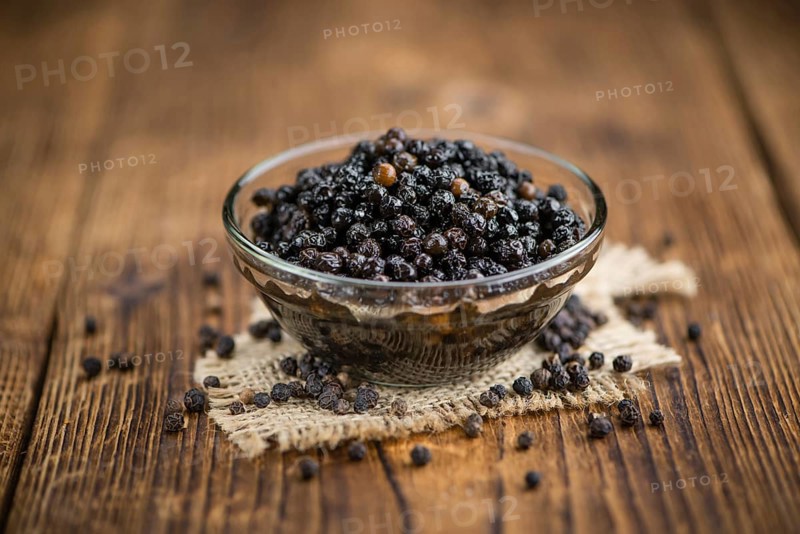 Preserved black Peppercorns on a wooden table as close-up shot