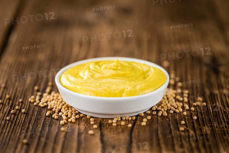Portion of homemade Mustard on wooden background (selective focus, close-up shot)