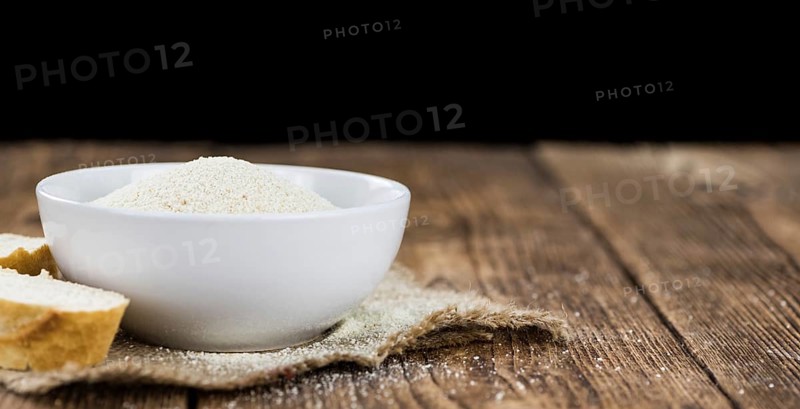 Some Bread Crumbs on a vintage wooden table (selective focus, close-up shot)
