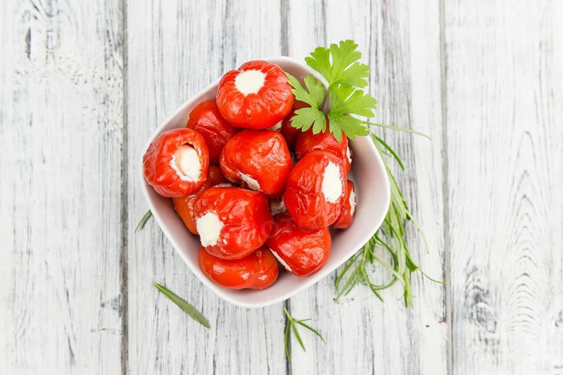 Fresh made Red Pepper (stuffed with cheese) on an old and rustic wooden table (selective focus, close-up shot)